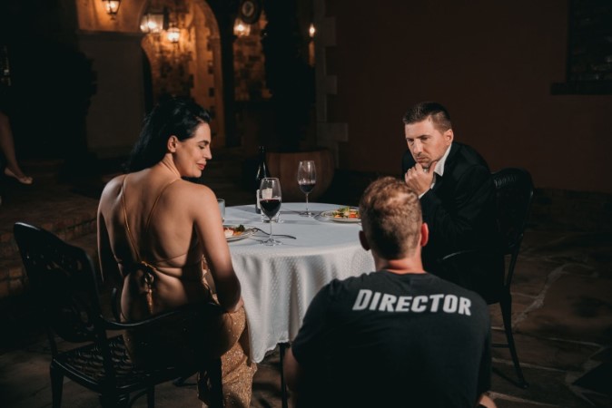 Σκηνοθέτης δίνει οδηγίες σε κομπάρσους κατά τη διάρκεια γυρίσματος σε εστιατόριο