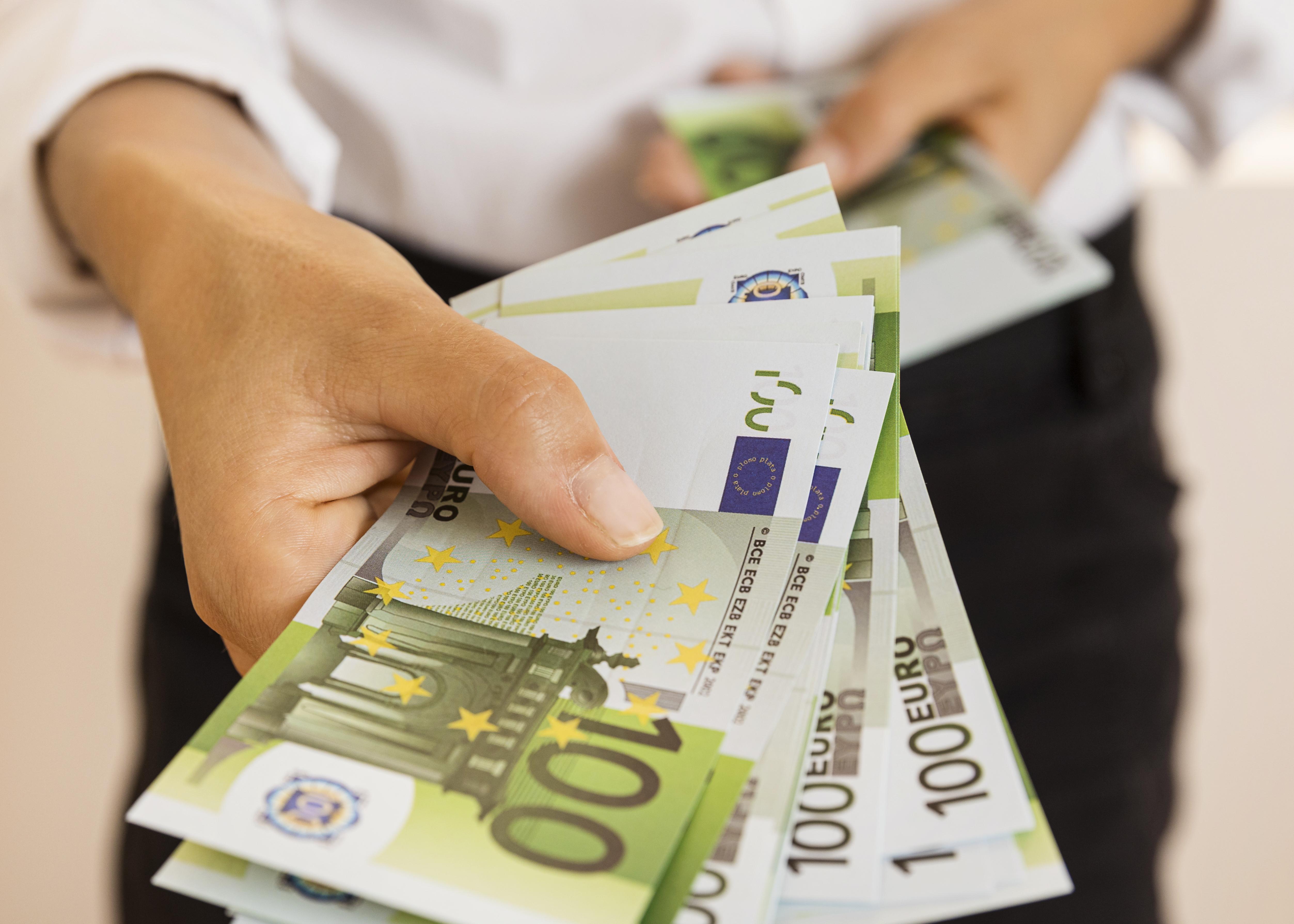 Χέρι που κρατά χαρτονομίσματα των εκατό ευρώ